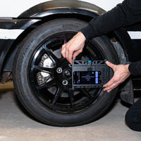 Person using a digital tool on a car tire